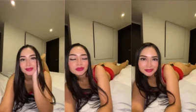 Laura Natali deitada na cama de bruços usando uma calcinha socada no rego